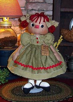 a doll that is sitting on a rug in front of a lamp and other items