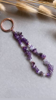 a keychain with amethorate beads on it next to dried wheat