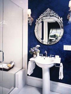 a white sink sitting under a bathroom mirror