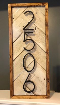 a wooden sign with the word welcome on it in black letters, sitting on top of a white shelf