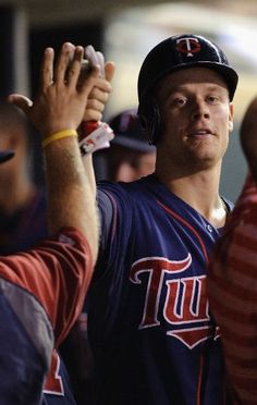 a baseball player is holding his hand up in the air while other players look on