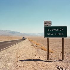 there is a sign that says elevation and sea level on the side of the road