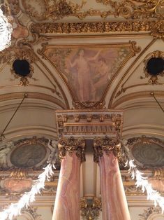 an ornately decorated room with columns and paintings on the walls, along with decorative plaster work