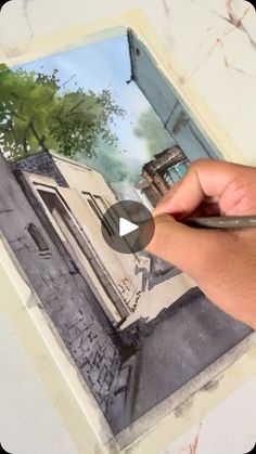 a person is painting an image on a piece of paper with watercolor pencils