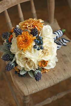 a bridal bouquet sitting on top of a wooden chair next to a zebra print pillow