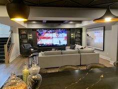 a living room filled with furniture and a flat screen tv mounted to the wall over a fireplace