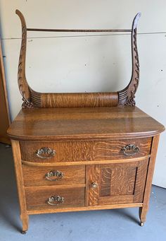 an old wooden dresser with two horns on it's top and drawers below the drawer