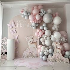 a room decorated with balloons, deers and other items in pastel colors on the walls