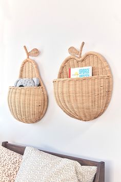 two woven apples hanging on the wall above a bed