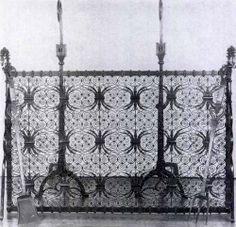 an ornate iron bed with two candles on it