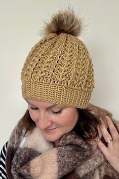 a woman wearing a hat and scarf with a pom - pom on it