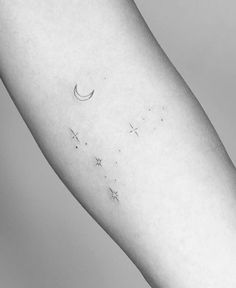 a woman's arm with stars and a crescent tattoo on the left inner arm