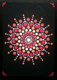 an abstract painting with red, white and black dots in the center on a black background