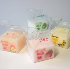 four different types of milk in containers on a table