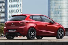 a red car parked in front of some tall buildings