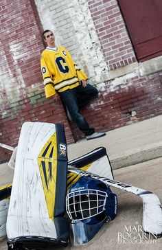 a hockey goalie standing next to an abandoned goalie's helmet on the sidewalk