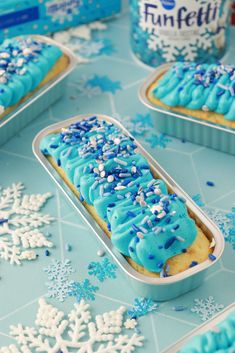 blue frosted cookies with sprinkles in tins