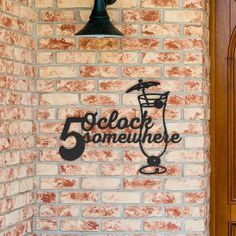 a brick wall with a sign that reads 5 o'clock somewhere