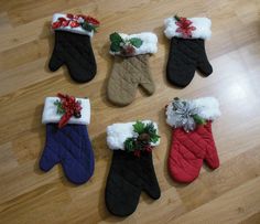 five pairs of mittens with christmas decorations on them sitting on a wooden floor next to a clock