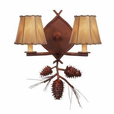 a wall mounted light with two lamps on it's sides and pine cones hanging off the side