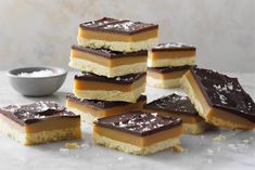 several pieces of dessert are stacked on top of each other with chocolate and caramel toppings