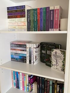 a book shelf filled with lots of books on top of white shelves next to each other