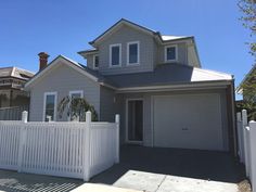 a house with a white fence in front of it