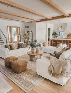 a living room filled with furniture and a large rug on top of a hard wood floor