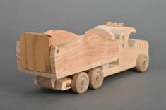 a wooden toy truck with wheels on a gray background