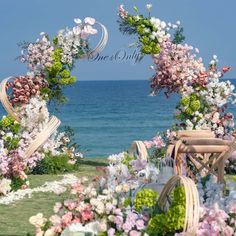 an outdoor wedding setup with flowers and chairs on the grass by the water's edge