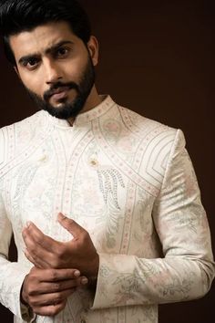 Ivory sherwani with mandarin collar, full sleeves, all over vintage pattern ekhtar resham embroidery and sequin work. Paired with silk kurta and cotton pyjama.
Components: 3
Pattern: Embroidered
Type Of Work: Ekhtar Resham and Sequin Work
Neckline: Mandarin Collar
Sleeve Type: Full Sleeves
Fabric: Sherwani: heavy Modal, Kurta: Silk, Pyjama: Cotton
Color: Beige
Other Details: 
Front concealed placket
Back placement embroidery
Front and side slits
Occasion: Groom,Wedding - Aza Fashions Designer Sherwani With Chikankari Embroidery And Long Sleeves, Designer Long Sleeve Sherwani With Chikankari Embroidery, Designer Long Sleeve Bandhgala For Diwali, Designer Long Sleeve Kurta, Designer Long Sleeve Traditional Wear For Transitional Season, Designer Nehru Jacket With Long Sleeves For Diwali, Designer Long Sleeve Nehru Jacket For Diwali, Designer Long Sleeve Kurta With Chikankari Embroidery, Designer White Nehru Jacket