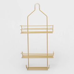 a gold metal rack with two shelves on each side and one shelf attached to the wall