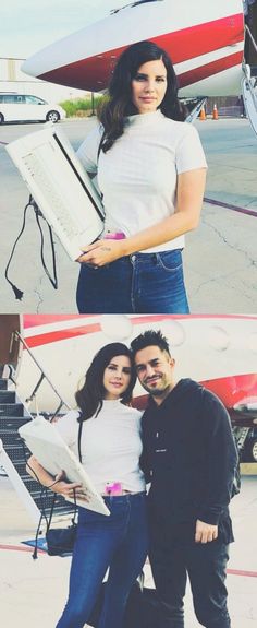 two people standing next to each other in front of an airplane