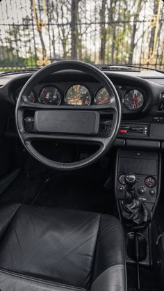 the interior of a car with black leather seats and gauges on it's dashboard