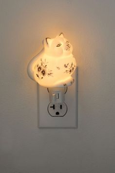 a light that is on the wall with a cat shaped light bulb attached to it