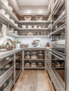 an organized kitchen with stainless steel appliances and wood flooring is seen in this image