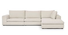 a white sectional couch with pillows on it's back and the seat folded out