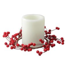 a white candle with red berries on it