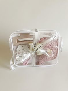 a clear plastic box filled with pink and white items on top of a white table