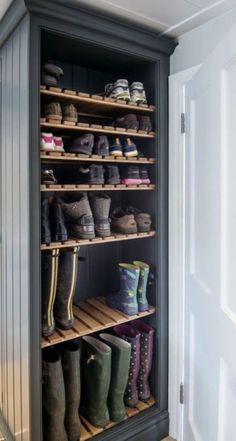 an open shoe rack with several pairs of boots on the bottom shelf and two rows of shoes