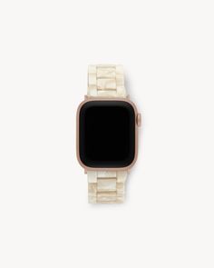 an apple watch sitting on top of a white surface with a gold case and black face