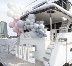 a white boat with balloons attached to it