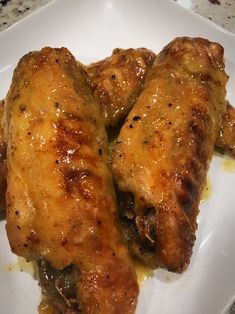 two pieces of chicken sitting on top of a white plate