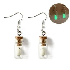 a pair of earrings with green glass bottles and corks hanging from the ear wires