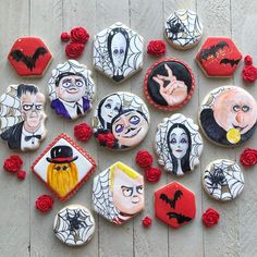 decorated cookies are arranged in the shape of halloween characters and roses on a wooden surface