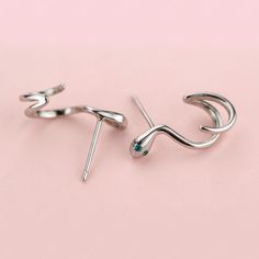 These fun sterling silver snake wrap stud earrings add a touch of whimsy to your day. The solid 925 sterling silver snakes are highly polished for a great shine, and plated in platinum or gold for an eye-catching finish. The snakes wrap around themselves in twisty cuffs, providing a unique and amusing option for everyday wear or as a gift to brighten someone's day. The snake wrap stud earrings make a fun addition to your fine jewelry collection or as a gift for a loved one who appreciates humoro Silver Snake Shape Metal Earrings, Silver Snake Shaped Metal Earrings, Silver Snake-shaped Metal Earrings, Silver Snake-shaped Earrings, Silver Snake-shaped Earrings For Pierced Ears, Silver Snake-shaped Single Earring, Silver Metal Ear Climbers As Gift, Silver Sterling Silver Snake-shaped Earrings, Trendy Silver Snake-shaped Jewelry