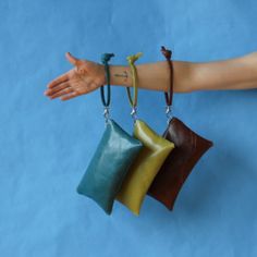 a woman's arm with three different colored purses hanging from it