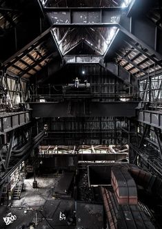 the inside of an industrial building with lots of steel beams and ladders on it