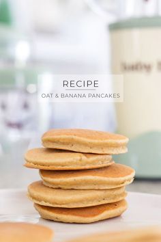 a stack of pancakes sitting on top of a white plate next to a blender