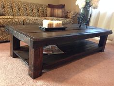 a living room with a couch, coffee table and candles on the end tables in front of it